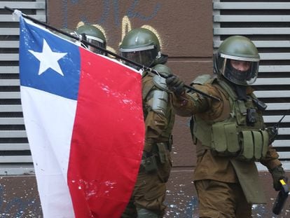 Un policía enarbola una bandera chilena en la Plaza Italia de Santiago (Chile), rebautizada popularmente como "Plaza Dignidad", el pasado 20 de octubre.
