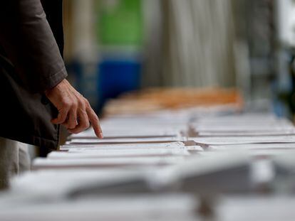 Un hombre observa las papeletas en un colegio electoral de Madrid este domingo durante las elecciones municipales y autonómicas.