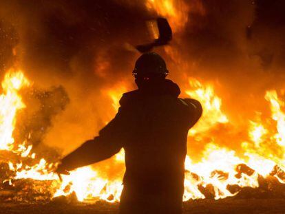 Un trabajador tira un elemento a una barricada durante un velatorio nocturno simbólico convocado por la fábrica de Alcoa, en San Cibrao, el pasado 28 de noviembre.