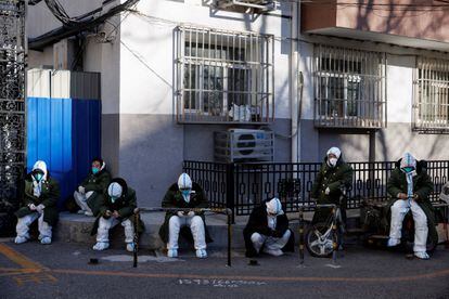 Empleados para controlar el covid, en un barrio de Pekín que solía estar confinado, este sábado. REUTERS/Thomas Peter