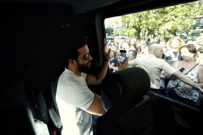 El músico tira una foto con su móvil a los seguidores que le esperan en la plaza. "¡Viva Valencia!", gritará desde la furgoneta.