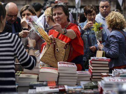 Una mujer adquiere un libro en una parada en La Rambla de Barcelona durante la festividad de Sant Jordi de 2019.