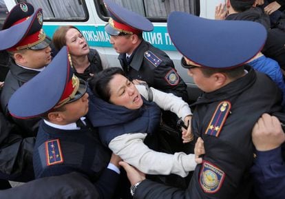 Policías retienen a una manifestante opositora al Gobierno este viernes en Almaty.
