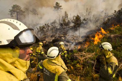 Miembros de la UME y brigadistas trabajando en Carnota. A las 11 de la mañana el incendio llegó a acorralar a tres viviendas pertenecientes a Ézaro en A Coruña