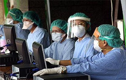 Médicos del hospital de la Universidad de Kaohsiung, en el sur de Taiwan, trabajan mientras se protegen contra el SARS.
