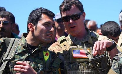 Un oficial militar estadounidense conversa con otro de la milicia kurda YPG tras un bombardeo turco en la poblaci&oacute;n siria de Al Malikiyah el pasado abril.