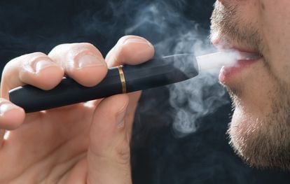 Un hombre fuma el calentador de tabaco IQOS de Philip Morris.