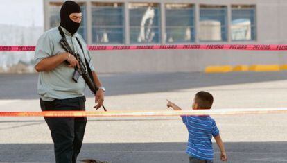 Un niño junto a un policía en la escena de un crimen.