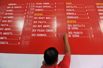 Un hombre actualiza los precios de los productos en un mercado en Buenos Aires.