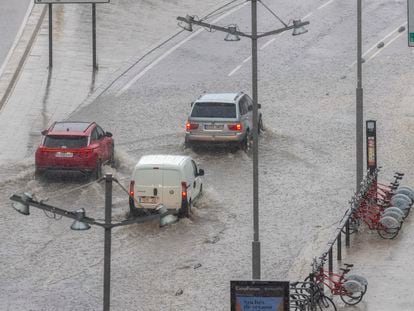 Unos coches circulan con dificultad tras la tormenta que ha caído este jueves en Zaragoza.