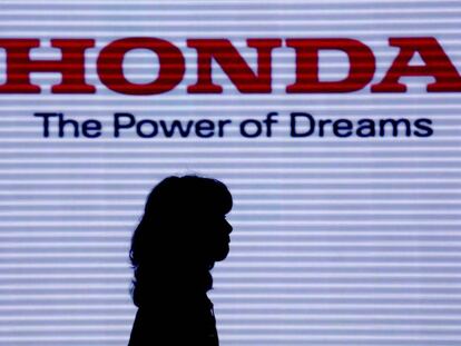 Una mujer pasa por delante del cartel de la firma japonesa Honda.