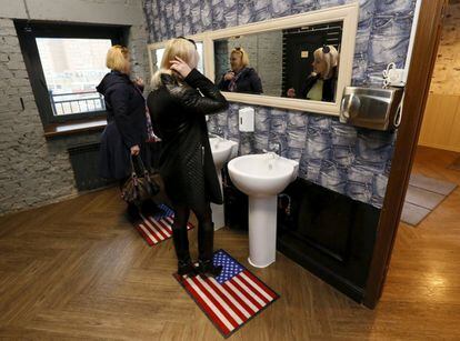 Dos clientas se miran al espejo en el servicio del President Cafe, en Siberia (Rusia), cuyas alfombrillas representan la bandera de los Estaods Unidos.