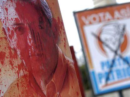 Un cartel de Otto Pérez Molina, candidato conservador a la presidencia de Guatemala, manchado de pintura roja.