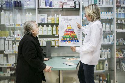 Una boticaria atiende a una anciana en una farmacia del programa.