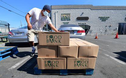 Un hombre carga cajas de comida de un banco de alimentos de Los Ángeles.