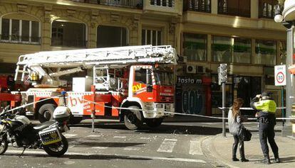 Los bomberos atienden un desprendimiento de la fachada en la avenida de María Cristina de Valencia.