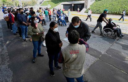 Un grupo de personas hace fila para recibir una dosis de la vacuna de Pfizer contra la covid-19, en la ciudad de México, el 28 de diciembre de 2021.