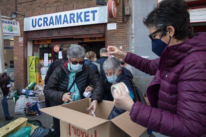 Tres mujeres se afanan en hacer cajas para enviar ayudas humanitarias a Ucrania y sus refugiados, en Madrid. 