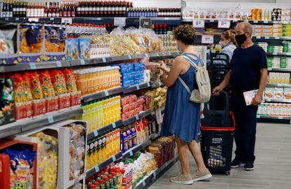 Unos clientes eligen productos en el supermercado.