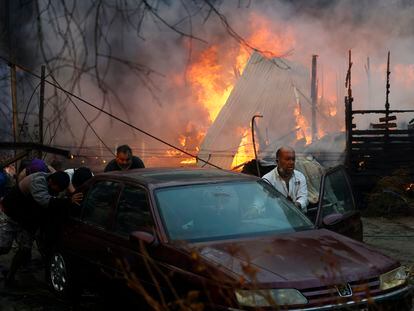 Residentes de Villa Alemana, en Valparaíso (Chile), empujan un automóvil para escapar de los incendios en la región, el pasado 2 de febrero.