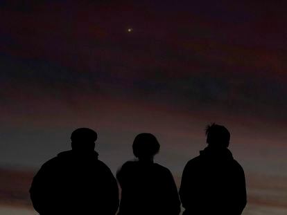 Tres personas observan el alineamiento de Júpiter y Saturno con la Tierra el pasado lunes en Kansas.