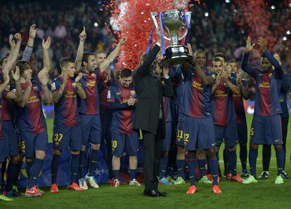 Vilanova, rodeado de sus jugadores, alza el trofeo de campeones de Liga conseguido por el Barcelona en la temporada 2012-13.