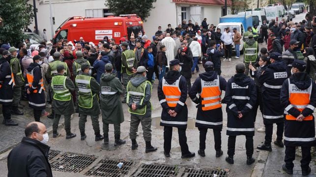 Emergency services gather at the site of illegal underground textile workshop that flooded after heavy rain fall in Morocco's city of Tangiers on February 8, 2021. - At least 24 people died after heavy rain flooded an illegal underground textile workshop in a private house in Morocco's port of Tangiers, the state news agency reported. Rescue workers recovered 24 bodies from the property and rescued 10 survivors who were taken to hospital, the MAP agency said citing local authorities. A search of the premises was continuing. (Photo by - / AFP)