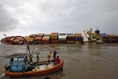 Pescadores indios fotografían al carguero 'MSC Chitra', volcado cerca de Bombay (India).