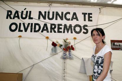 Sonia Molina, que perdió a su hijo Raúl en el terremoto del 11 de mayo de 2011, en el que ella también resultó herida, ante el cartel que recuerda a Raúl en el chiringuito que regenta en el parque del barrio de La Viña.