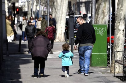 Unos padres pasan junto a su hija en el primer día sin colegio por el riesgo del coronavirus, en Madrid (España).