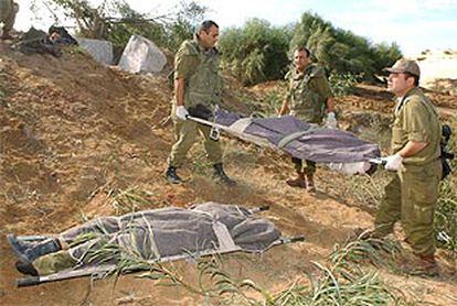 Soldados israelíes recogen los cadáveres de dos militantes de Hamás que atacaron a un grupo de militares cerca de una colonia judía en Gaza.