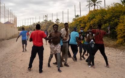 Sub-Saharan migrants celebrate their arrival in Melilla, after having jumped the fence, this Friday.