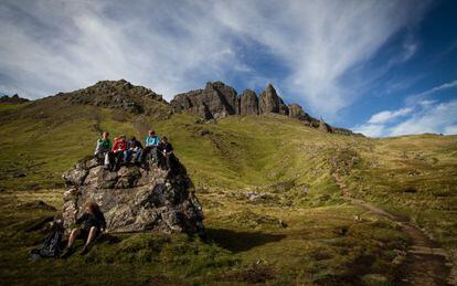 Estudiantes en una excursi&oacute;n al cerro rocoso de Old Man of Storr, que se ve al fondo, en la isla de Skye (Escocia). 