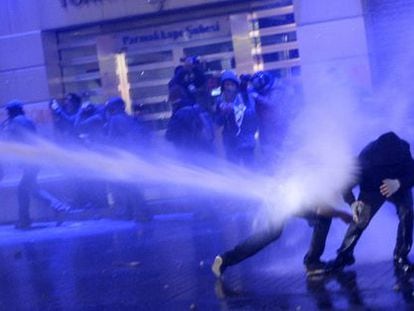 Los antidisturbios lanzan un ca&ntilde;&oacute;n de agua contra dos manifestantes esta noche en Estambul. 
