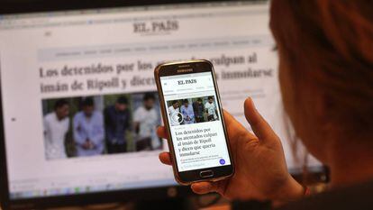 Una lectora de El Pa&iacute;s consulta la p&aacute;gina en su tel&eacute;fono m&oacute;vil.