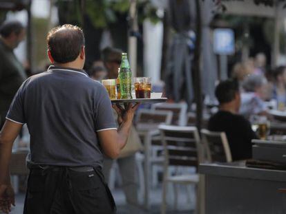 Un camarero sirviendo bebidas en una terraza en Madrid