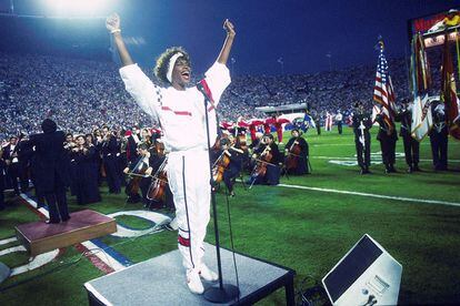 Mucho antes que Shakira o Jennifer Lopez, estaba Whitney Houston poniendo los pelos de punta a todos los espectadores de la Super Bowl, en 1991, cantando el himno de Estados Unidos. No necesitó ni el brillo de una lentejuela: le sobró con un sencillo chándal tricolor.
Según la Rae, que recoge el término desde 1983, un chándal es un tipo de “ropa deportiva que consta de un pantalón y una chaqueta o jersey amplios”. Su origen etimológico, poco refinado, hace referencia a la vestimenta de los tenderos parisinos a finales del siglo XIX: “Procede de la expresión marchand d’ail, ‘frutero y verdulero’ y, literalmente, ‘vendendor de ajos”, recuerda Juan Gil, catedrático de Filología, en el libro 300 historias de palabras.