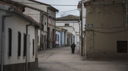 Un hombre camina por una calle desierta de Alaraz, uno de los pueblos vac&iacute;os de Salamanca.