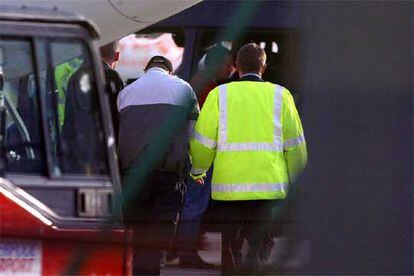 Un policía custodia a un detenido, sospechoso del asesinato del joven Anthony Walker, en Liverpool.