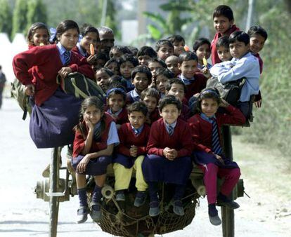 Más de 35 niños vuelven de la escuela subidos en un carro en las afueras de Nueva Delhi.