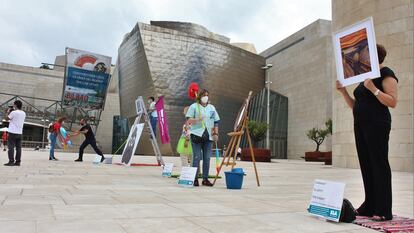 Los trabajadores de la limpieza del Guggenheim realizan una 'performance' de protesta sobre obras de arte frente a la sede del museo.