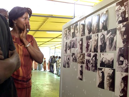 Una mujer observa, el 29 de septiembre de 2002, tres días después del accidente del Joola, fotos de cadáveres encontrados.