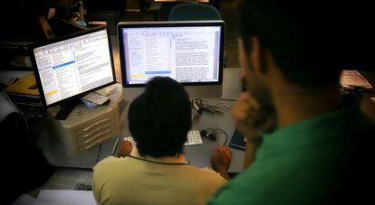 Un trabajador lee el correo electrónico en un ordenador de la oficina.