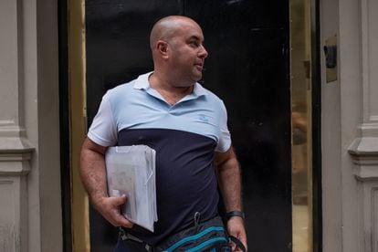 Ignacio Nani Diaz carries his grandfather's documents under his arm, in line in front of the Spanish embassy in Buenos Aires.