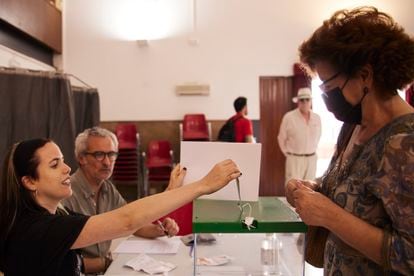 La presidenta de una mesa mete un voto en la urna el día de las elecciones andaluzas en un colegio electoral de Sevilla.