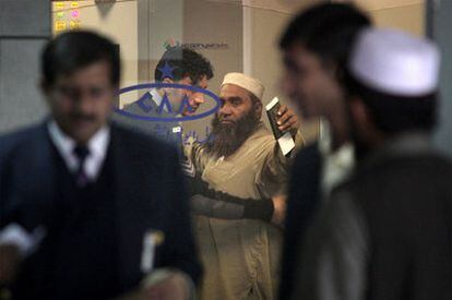 Un guardia de seguridad cachea a un pasajero en el aeropuerto de Islamabad (Pakistán).