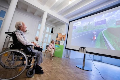 Un anciano juega en una residencia de mayores de Düsseldorf, en Alemania, a un simulador de conducción de una motocicleta, que maneja con los movimientos de sus manos.