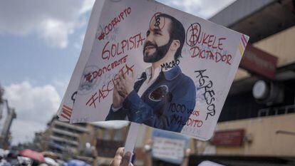 Un manifestante levanta una pancarta en contra de Nayib Bukele, durante una protesta en San Salvador.