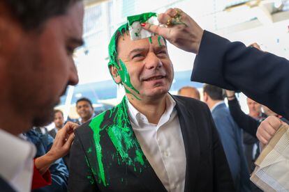 Luís Montenegro smiles after a climate activist threw paint at him, at an electoral event at the Lisbon Fair Tourism Fair, on February 28. 