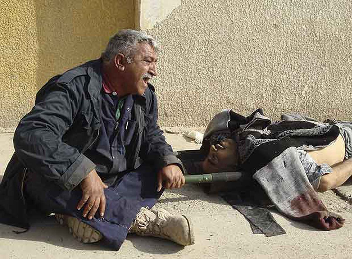 Un Hombre Llora Cerca Del Cadáver De Su Hermano, Muerto Al Estallar Una ...